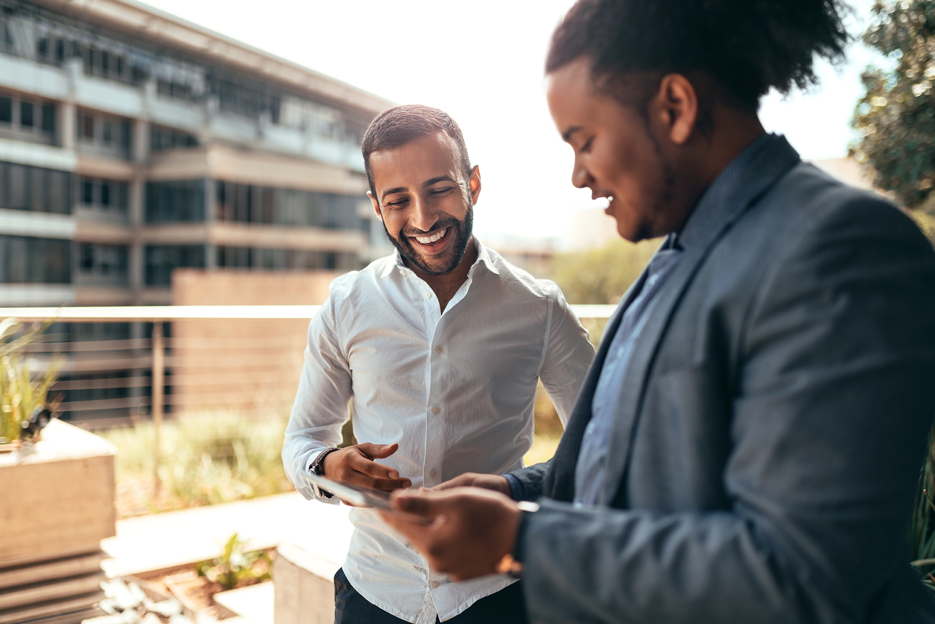 Dos hombres hablando en inglés en un campus universitario.