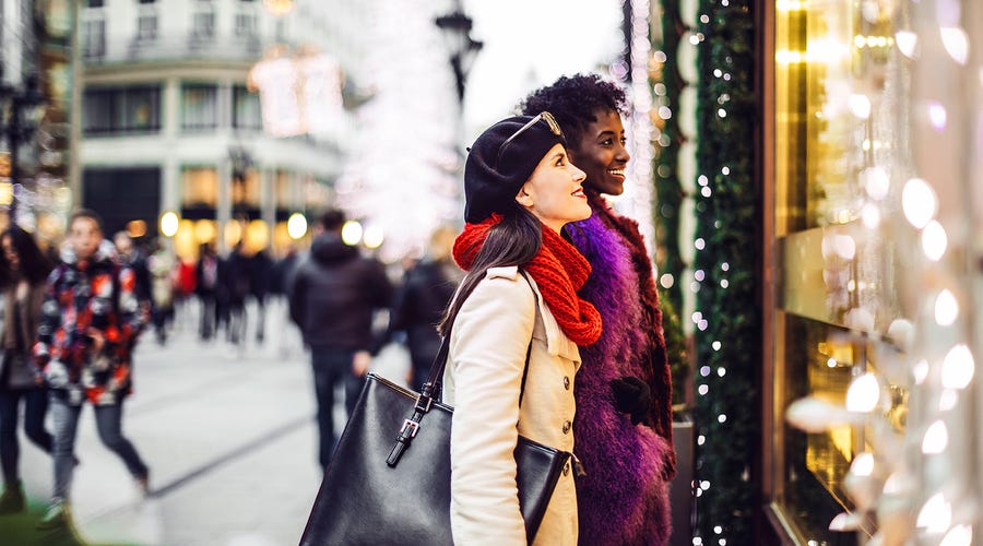 Dos mujeres jovenes, paseando en la calle durante navidad en Inglaterra