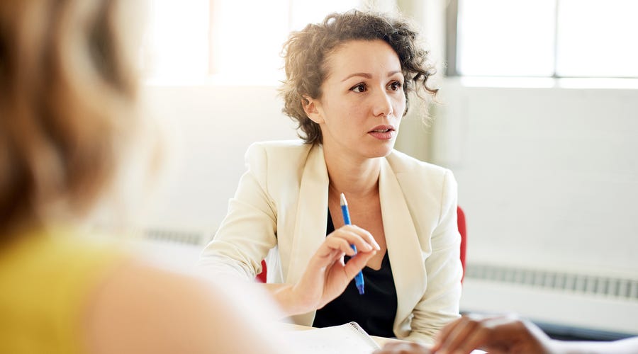 Mujer discutiendo en grupo en una clase.