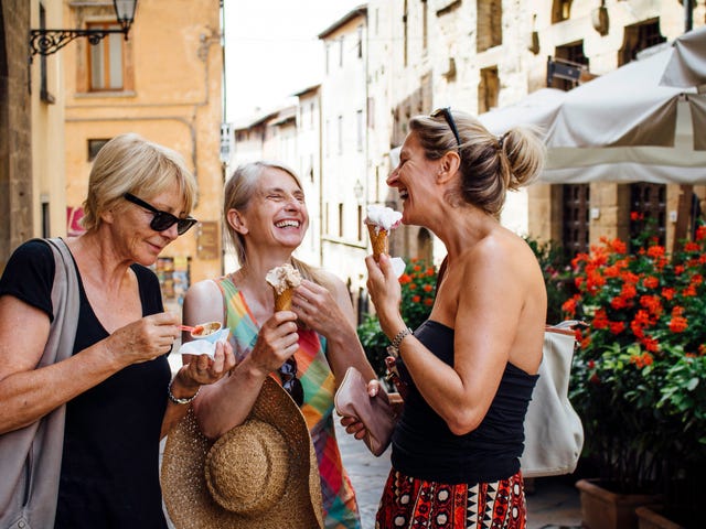 Three happy laughing older women in a foreign country, exploring the best places to retire abroad.