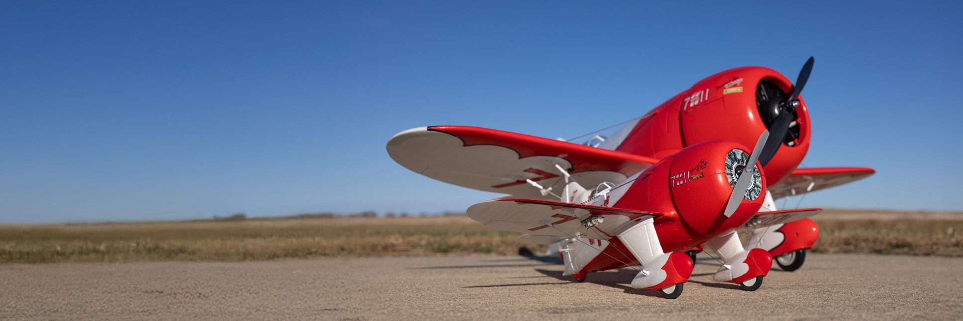 Glamour shot of the E-flite UMX Gee Bee R-2 510mm Bind-N-Fly Basic RC Plane with AS3X and SAFE Select sitting in front of the E-flite Gee Bee R-2 1.0m RC Airplane in the background
