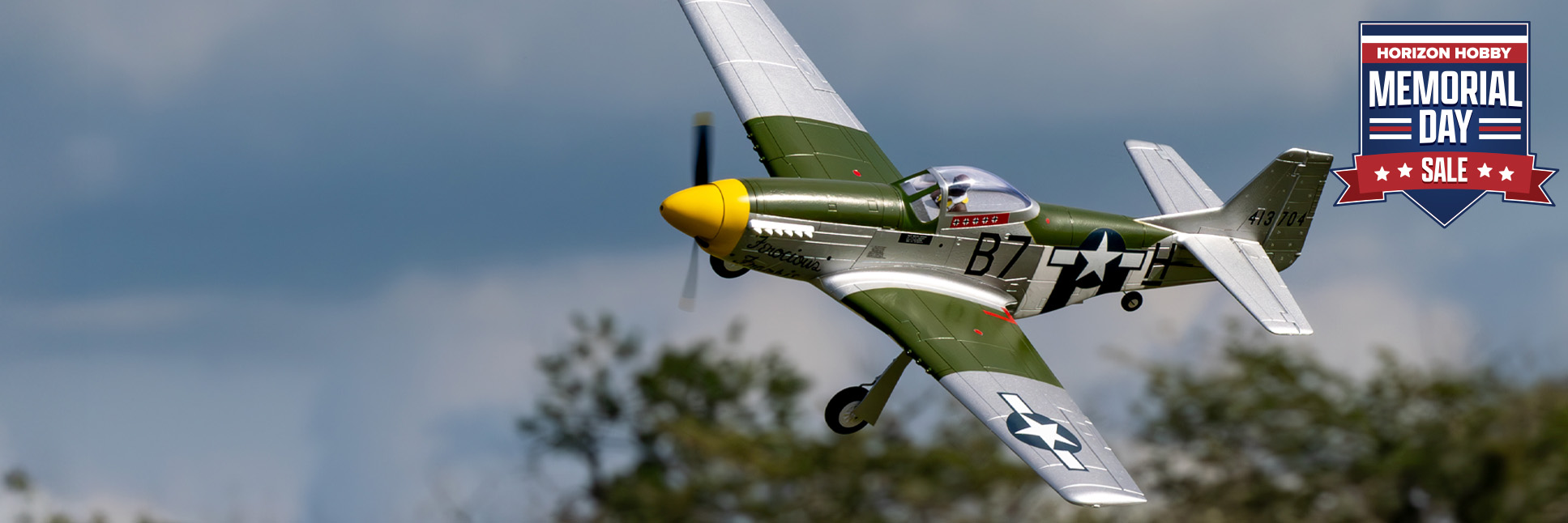 Action shot of E-flite P-51D Mustang 1.0M Bind-N-Fly Basic RC Plane AS3X and SAFE Select with the Memorial Day Sale Logo Action shot of E-flite P-51D Mustang 1.0M Bind-N-Fly Basic RC Plane AS3X and SAFE Select with the Memorial Day Sale Logo
