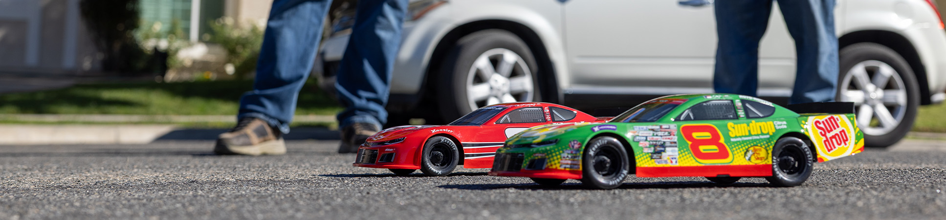 Action shot of a two people driving the Losi 1/12 Asphalt Late Model Dale Earnhardt Jr. No. 8 Ready-to-Run On-Road RC Race Car 