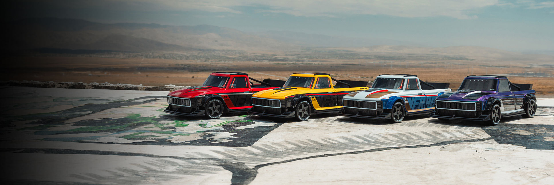 Action shot of the ARRMA 1/12 INFRACTION GROM Ready-To-Run Brushless All-Road Street Bash in Red/Black, Yellow/Black, Blue/Red, and Limited Edition Blue/Black on a cliffside