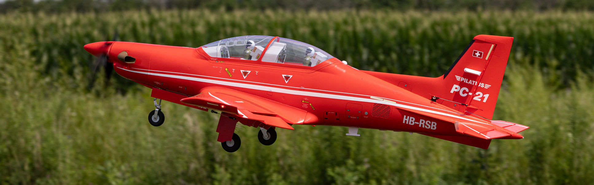 Action shot of the E-flite Pilatus PC-21 1.3m RC aircraft flying above a grassy field