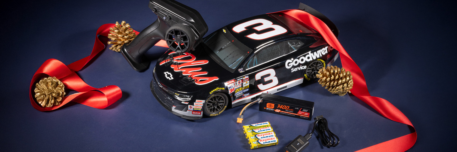 All In One Box Gifts banner featuring the Losi 1/12 NASCAR RC Race Car RCR No. 3 GM Goodwrench Chevrolet ZL1 2S AWD Ready-to-Run Brushed On-Road with festive holiday themed background