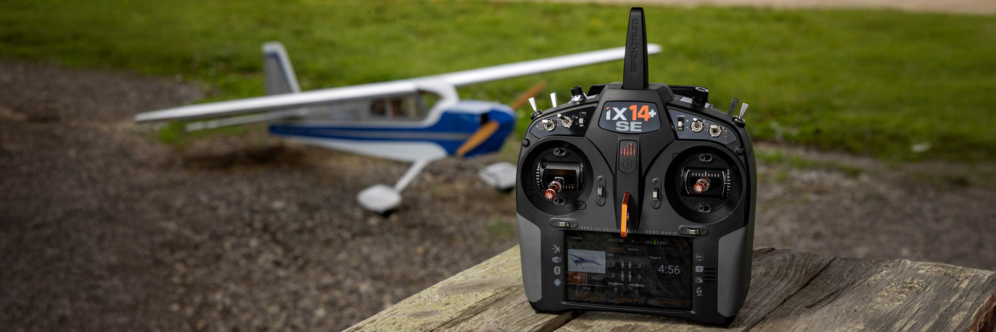 Action shot of the Spektrum iX14+ SE 20-Channel DSMX Transmitter on a bench with the Hangar 9 Valiant 20cc RC airplane in the background Action shot of the Spektrum iX14+ SE 20-Channel DSMX Transmitter on a bench with the Hangar 9 Valiant 20cc RC airplane in the background