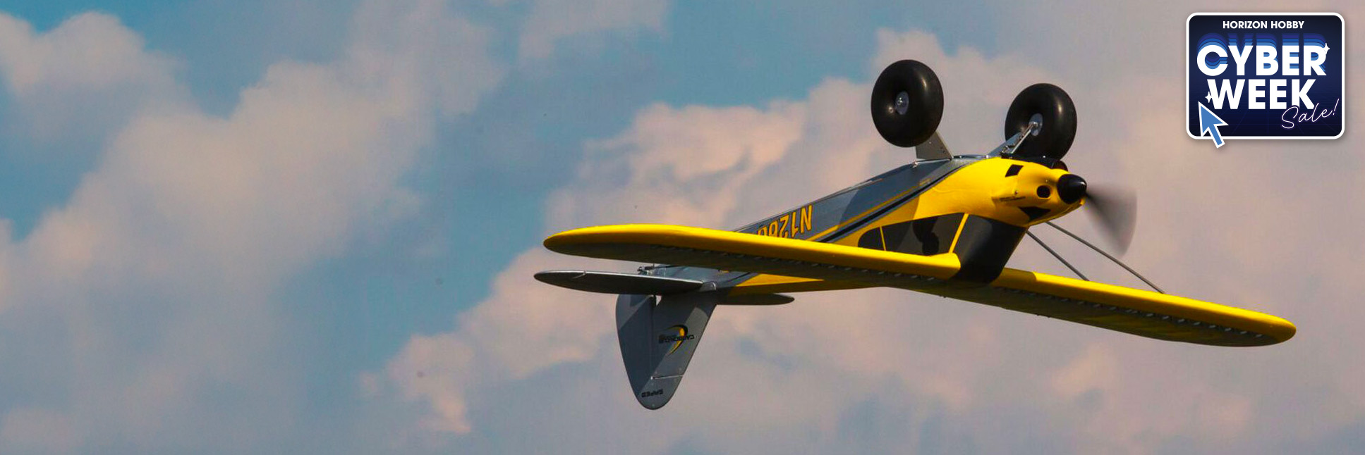 Action shot of the HobbyZone Carbon Cub S 2 1.3m Ready-to-Fly Basic RC Trainer Airplane flying upside down with the Cyber Week Sale Logo