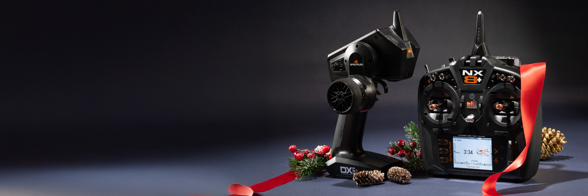 Glamour shot of the Spektrum DX Pro+ 12-channel DSMR+ Surface Transmitter and the NX8+ 20-channel DSMX Aircraft Transmitter with a festive holiday themed background