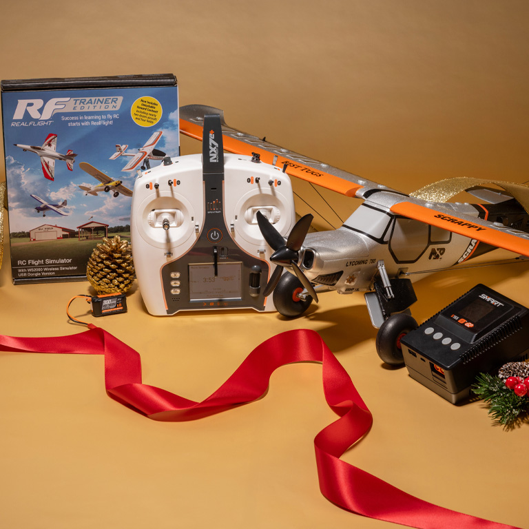 Micro Scrappy 800mm BNF Basic Ultimate Combo with the Spektrum NX7e+ Transmitter, S155 55W AC G2 Smart Charger, 300mAh 4S 30C LiPo Battery and RealFlight Trainer Edition RC Flight Sim with a holiday themed festive background