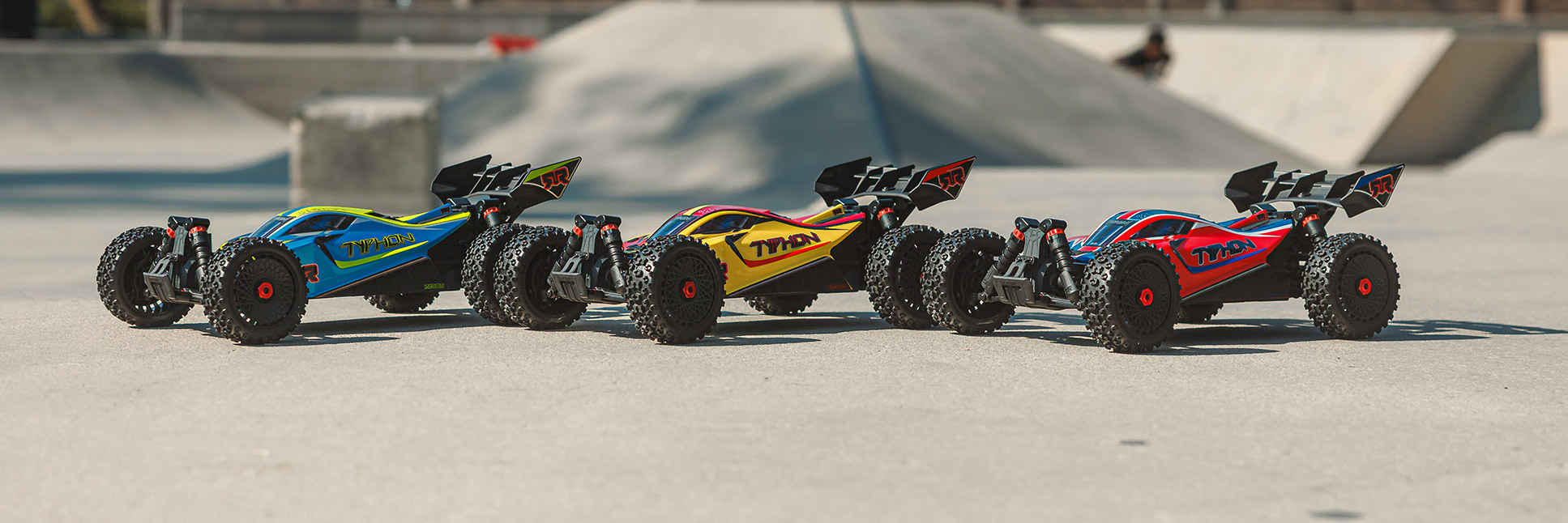 ARRMA 1/8 TYPHON MEGA 665 4X4 Ready-to-Run Brushed RC Buggy in Blue, Yellow, and Red at a Skatepark
