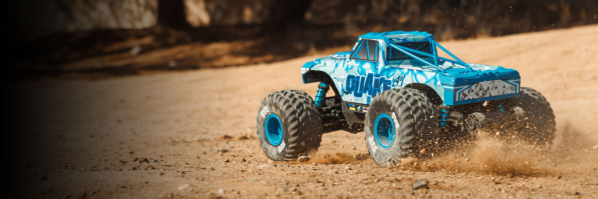 Action shot of the 1/8 QUAKE 4S DSC 4X4 RTR Brushless Monster Truck in Blue bashing through dirt