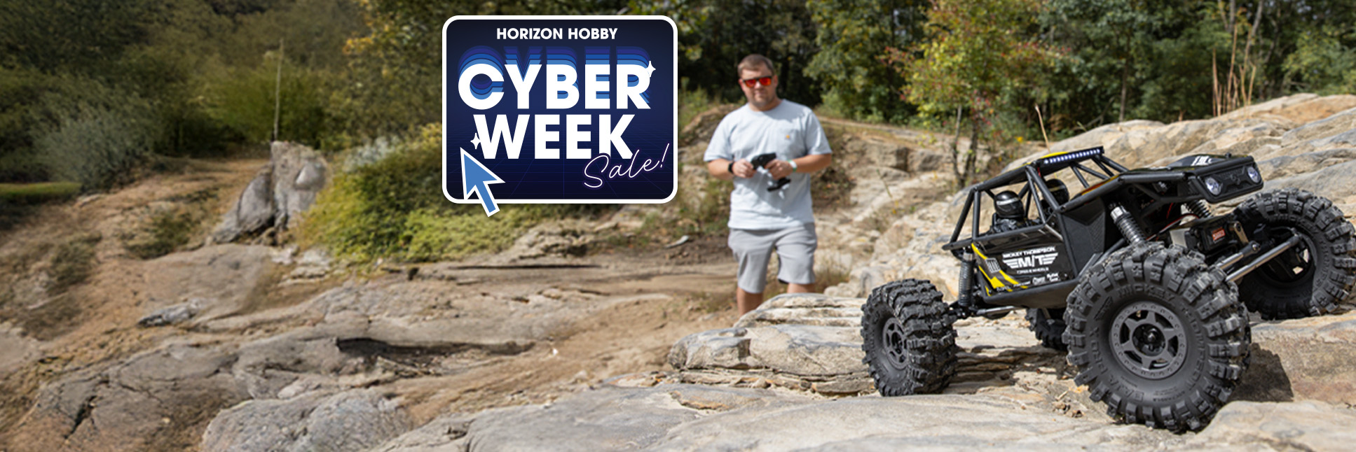 Lifestyle shot of a person driving the Axial 1/10 UTB10 Capra 1.9 4WS 4X4 Ready-to-Run Brushed RC Rock Crawler Yellow with the Cyber Week Sale Logo
