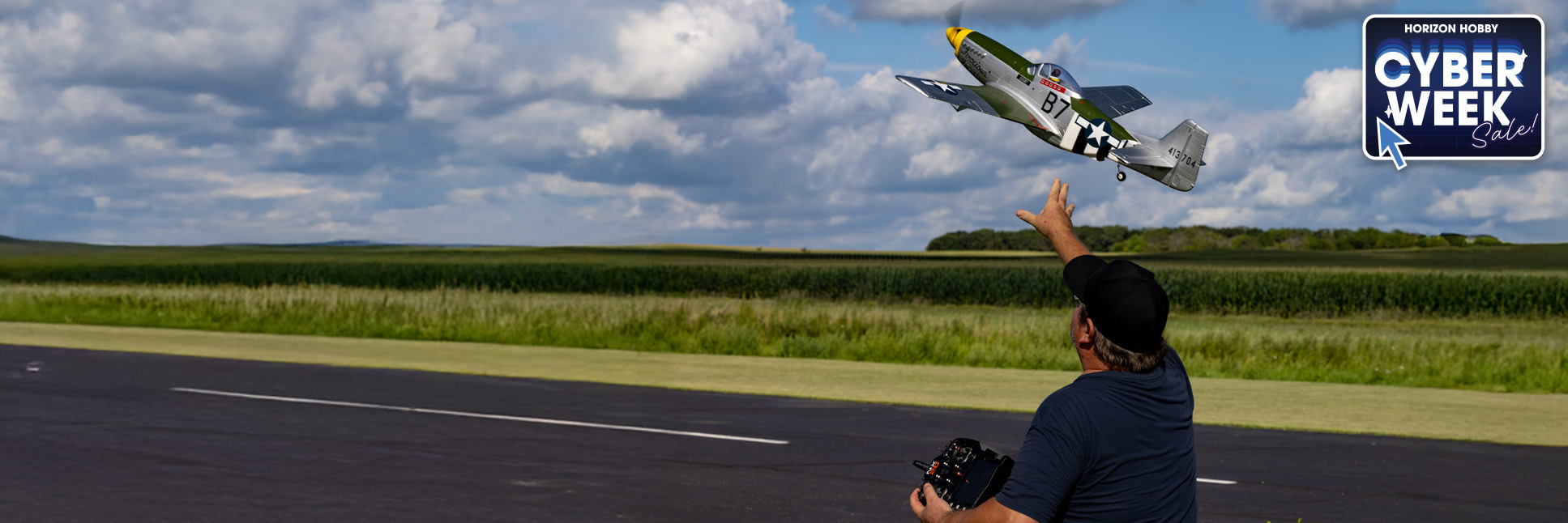 Lifestyle shot of a person hand launching the P-51D Mustang 1.0m Bind-N-Fly Basic AS3X+ and SAFE Select RC Airplane with the Cyber Week Sale Logo
