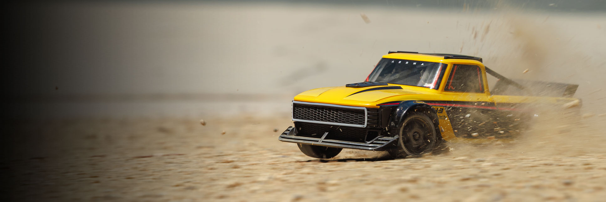 Action shot of the ARRMA 1/12 INFRACTION GROM Ready-To-Run Brushless All-Road Street Bash in Yellow/Black bashing through dirt Action shot of the ARRMA 1/12 INFRACTION GROM Ready-To-Run Brushless All-Road Street Bash in Yellow/Black bashing through dirt