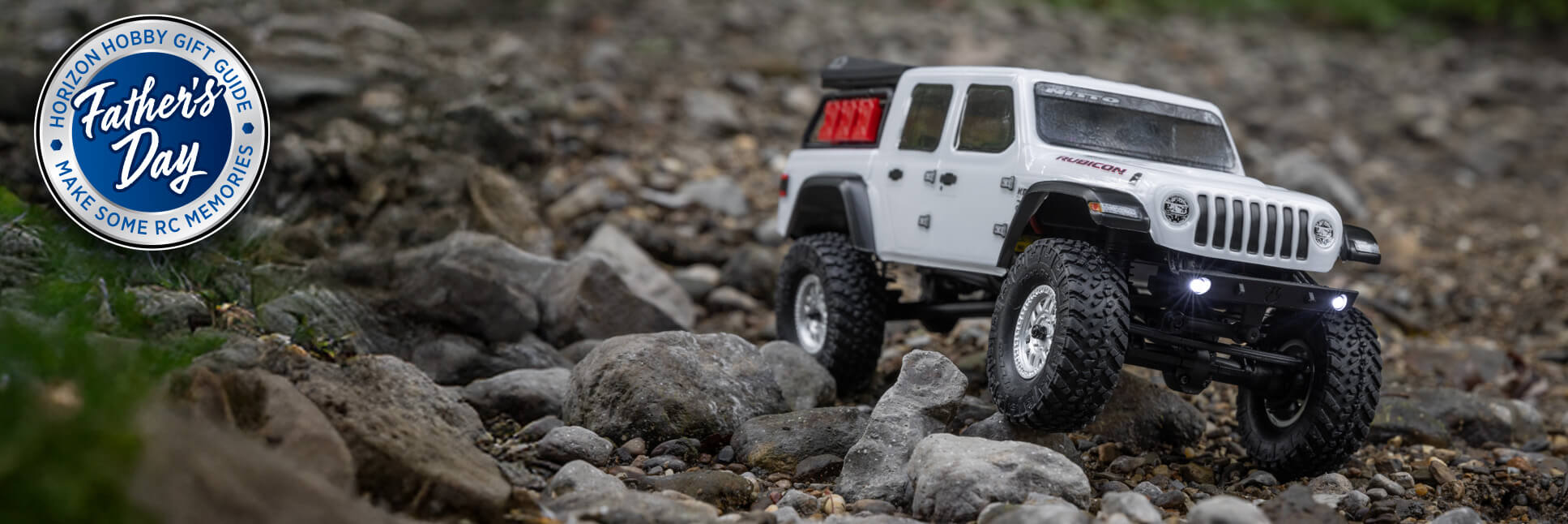 Glamour shot of Axial 1/24 SCX24 White Jeep JT Gladiator 4X4 Ready-to-Run Brushed RC Rock Crawler with Horizon Hobby Father's Day 2025 Logo