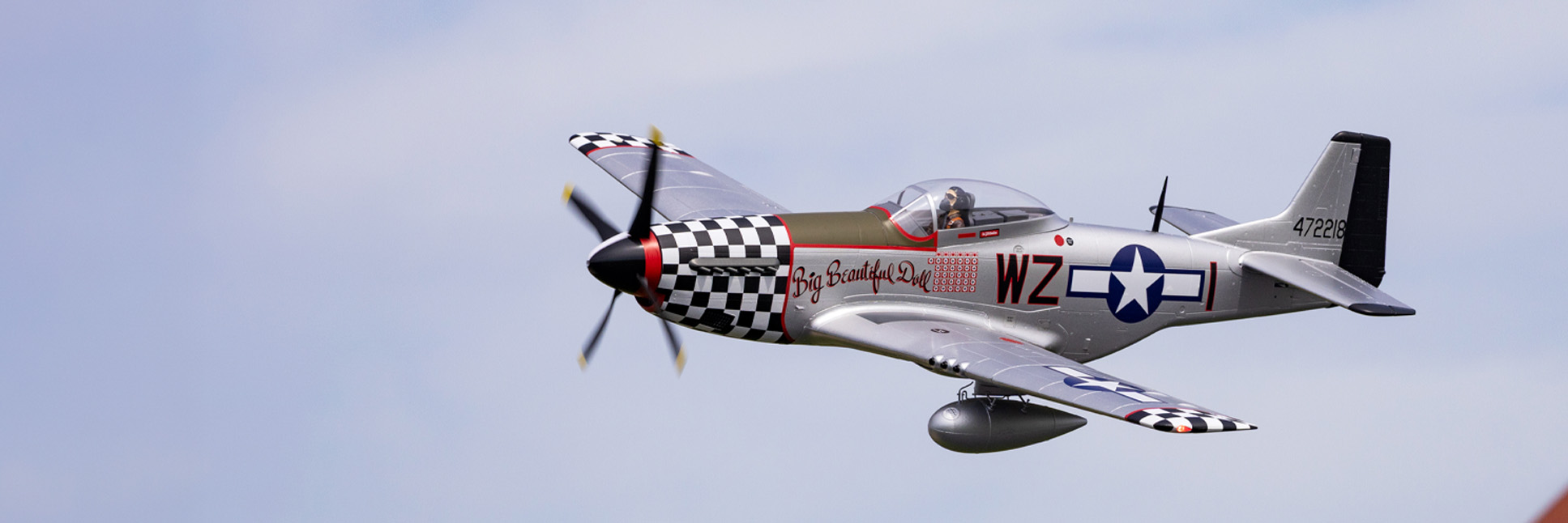Action shot of the E-flite P-51D Mustang "Big Beautiful Doll" 1.5m RC airplane flying through the sky