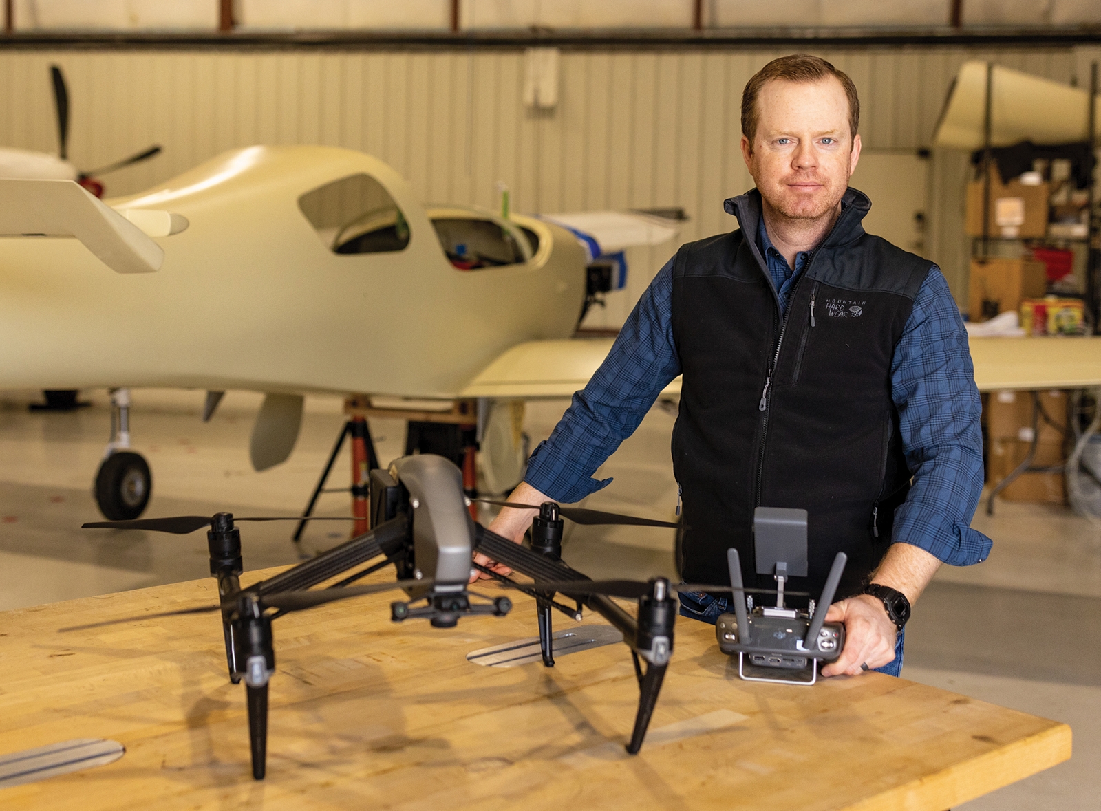 Jon Gruber in his hangar with a plane and drone