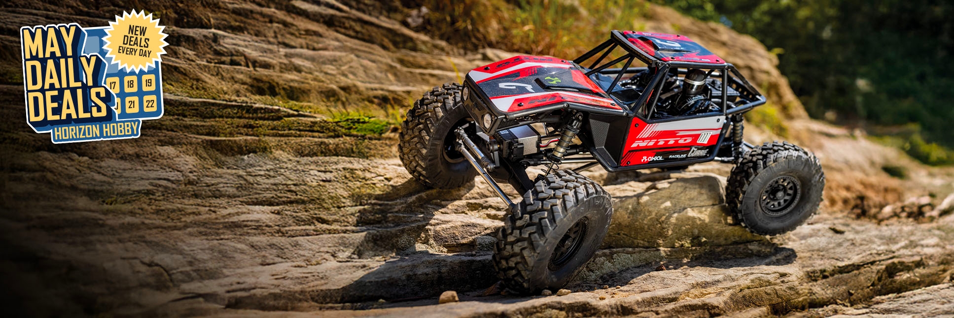 Action shot of Axial 1/10 Capra 1.9 4WS Nitto Unlimited Trail Buggy Ready-to-Run RC Crawler with the May Daily Deals Logo