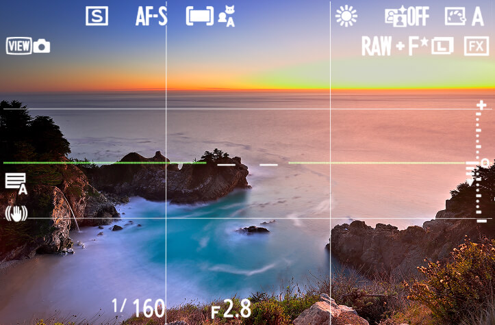 A photograph overlooking the ocean during sunset overlayed with the Z5II's virtual horizon and grid view indicators.