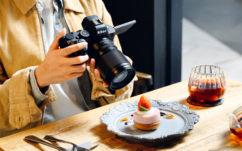 photo of a person taking a picture of food with the NIKKOR Z 24-105mm f/4-7.1 lens