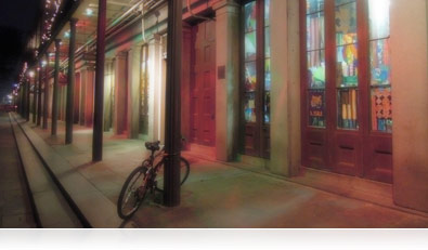 Foto nocturna de Rango Dinámico Alto (HDR) con retroiluminación de los frentes de las tiendas de una calle de Nueva Orleans, Louisiana 