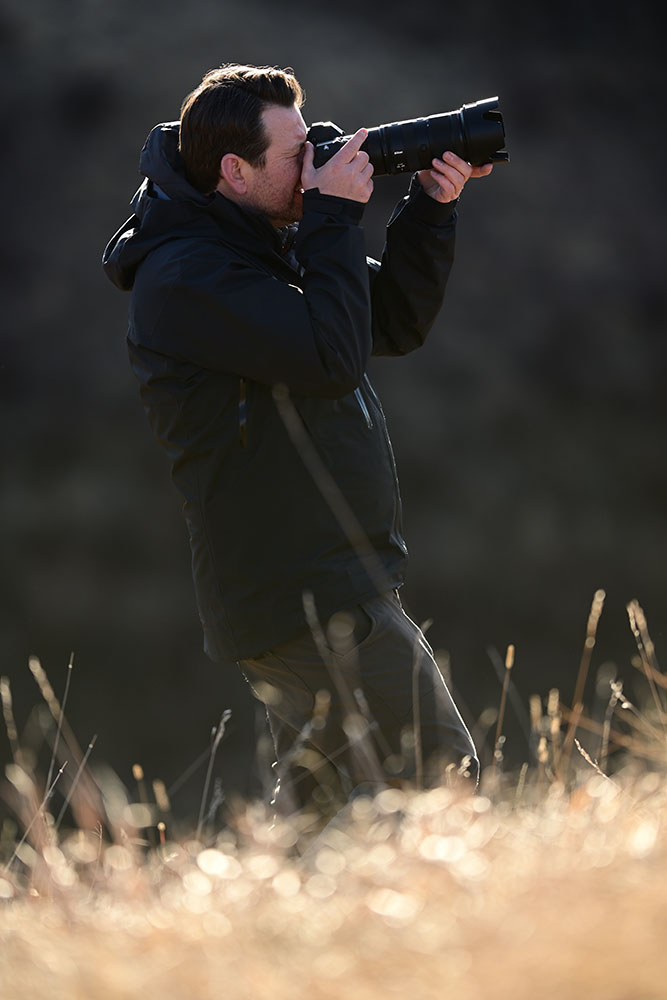 Photo of Kristian Bogner taking photos on location in the snow with the NIKKOR Z 70-200mm f/2.8 VR S II lens