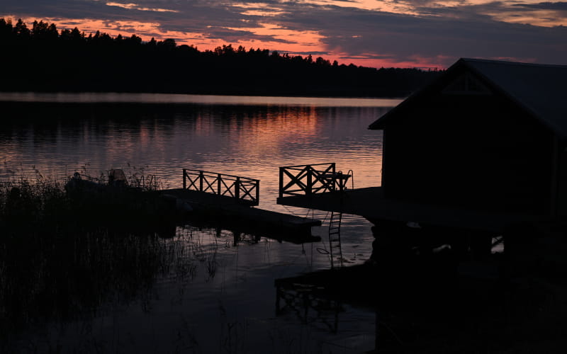 photo of a house by a lake at sunset, in very low light, taken with the NIKKOR Z DX 16-50mm f/2.8 VR lens