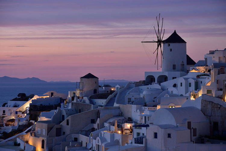 A villiage in Greece with a purple sky in the background