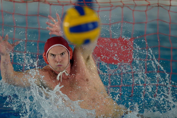 A man jumping to prevent a goal in water polo