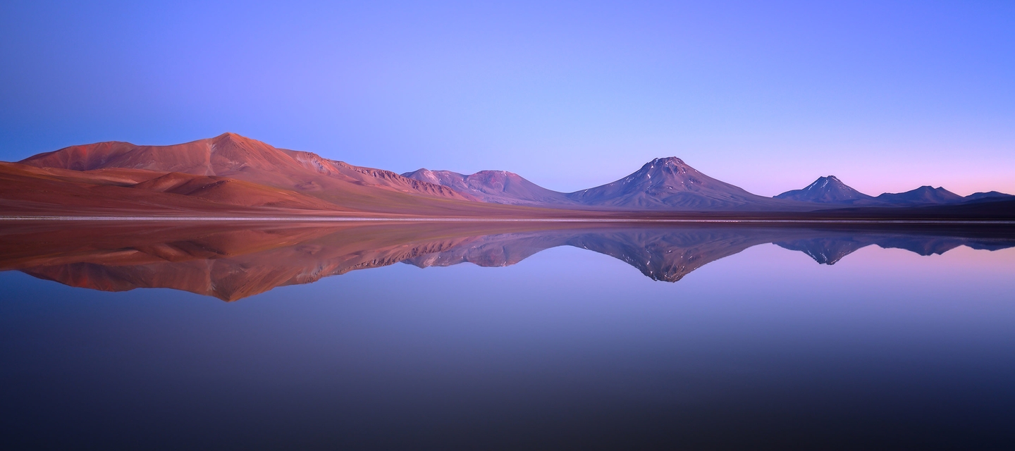 Landscape photo of hills and their reflection in water, taken with the NIKKOR Z 20mm f/1.8 S