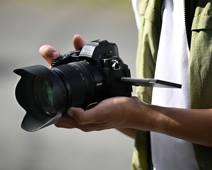 photo of a person holding a Nikon mirrorless camera and NIKKOR Z DX 16-50mm f/2.8 VR lens