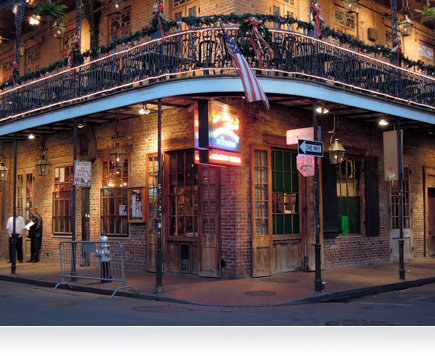 Foto nocturna de un edificio en una esquina de Nueva Orleans, Louisiana