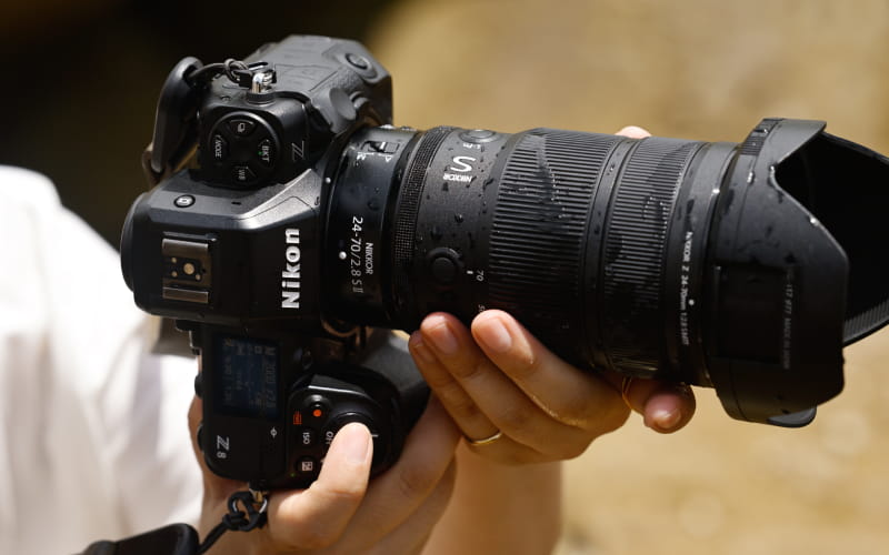 photo of the NIKKOR Z 24-70mm f/2.8 S II on a camera in a photographer's hands