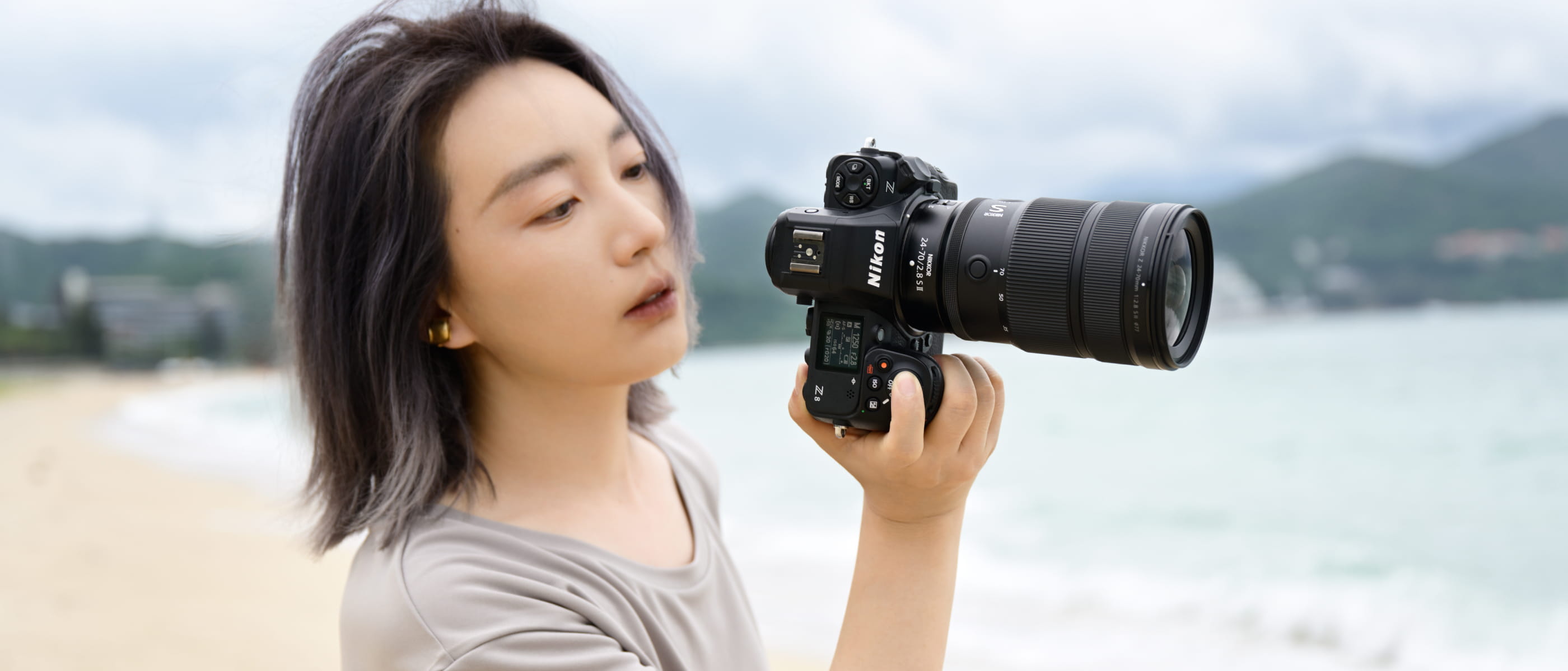 Photo of a woman holding the NIKKOR Z 24-70mm f/2.8 S II on a Nikon Z camera