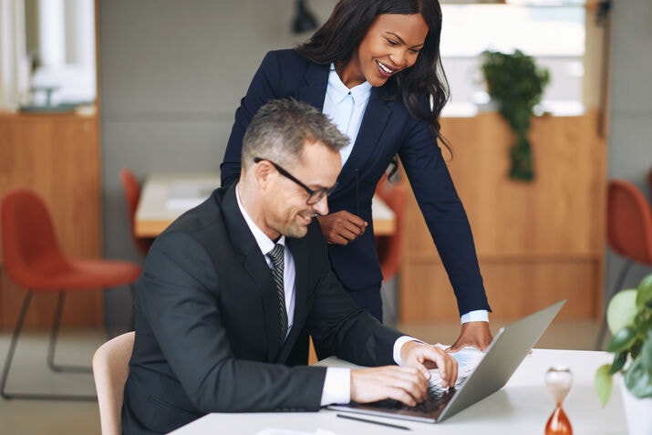 lawyers smiling and working together on laptop automation