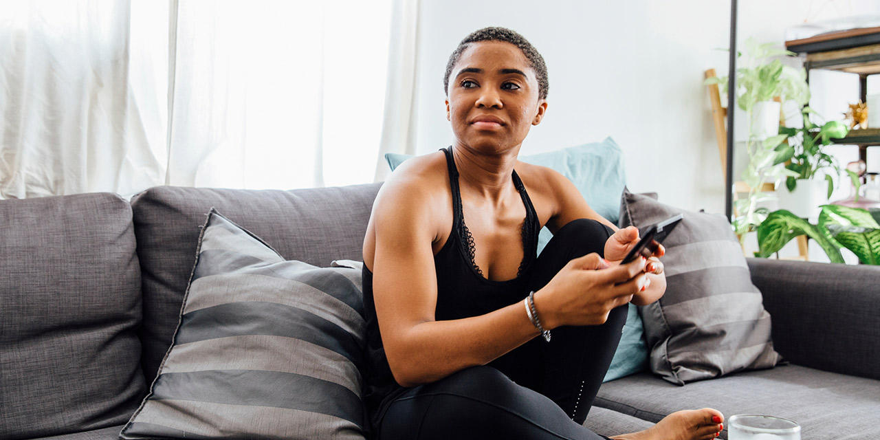 A woman at home sitting on her couch trying to understand what she wants for her future.