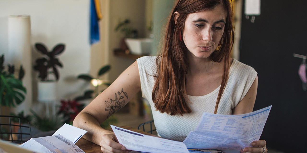 A woman reading about different ways to pay off debt.