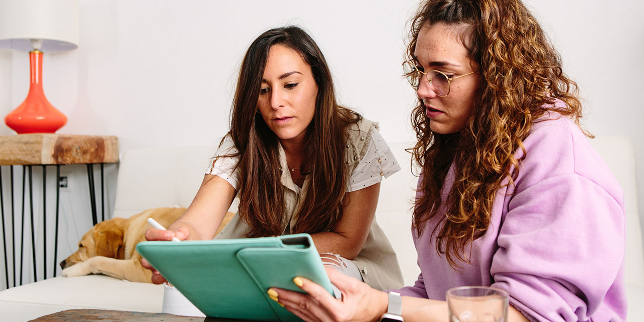 Two women reviewing notebook