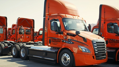 A group of Schneider's eCascadia fleet parked in the lot of their South El Monte, California facility.