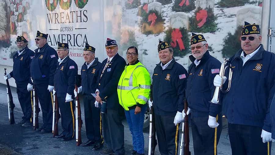 Schneider Ride of Pride Driver stands in front of Wreaths Across America semi trailer
