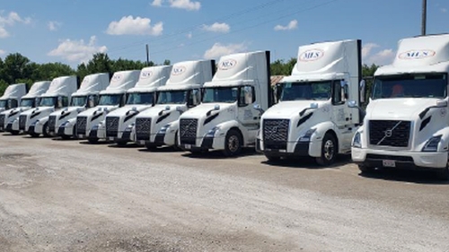 MLS trucks parked outside.