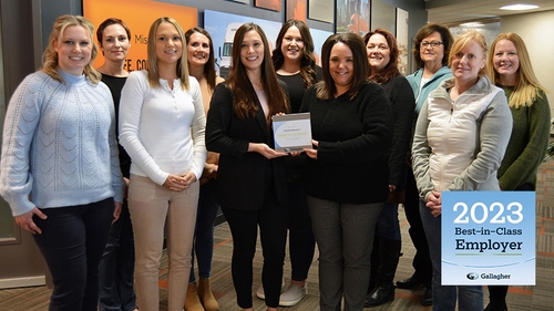Associates part of Schneider's HR team gather holding the 2023 Gallagher Best-in-Class Employer award