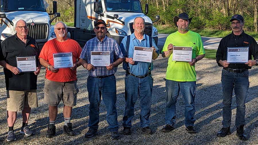Seven Schneider drivers from Kenton, Ohio, each holding a certificate