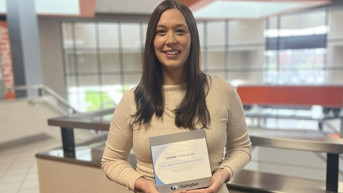 Carrie DeClark holds Gallagher's 2022 Best in Class Employer Award in Schneider's corporate office in Green Bay, Wisconsin.