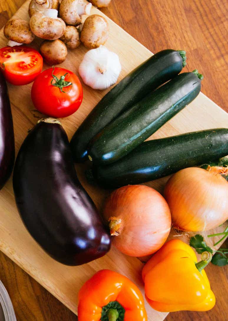 Fresh vegetables on cutting board and eggs in bowl