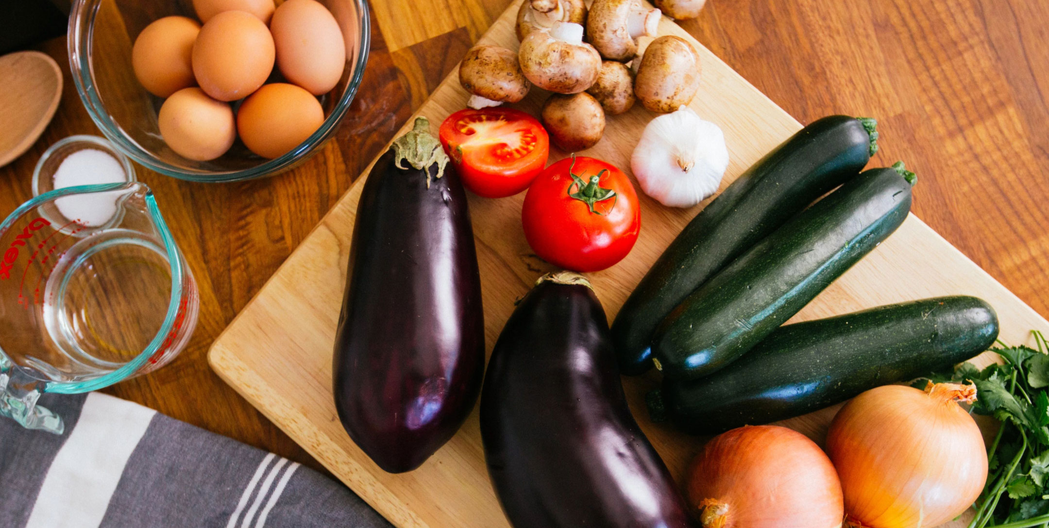 Fresh vegetables on cutting board and eggs in bowl