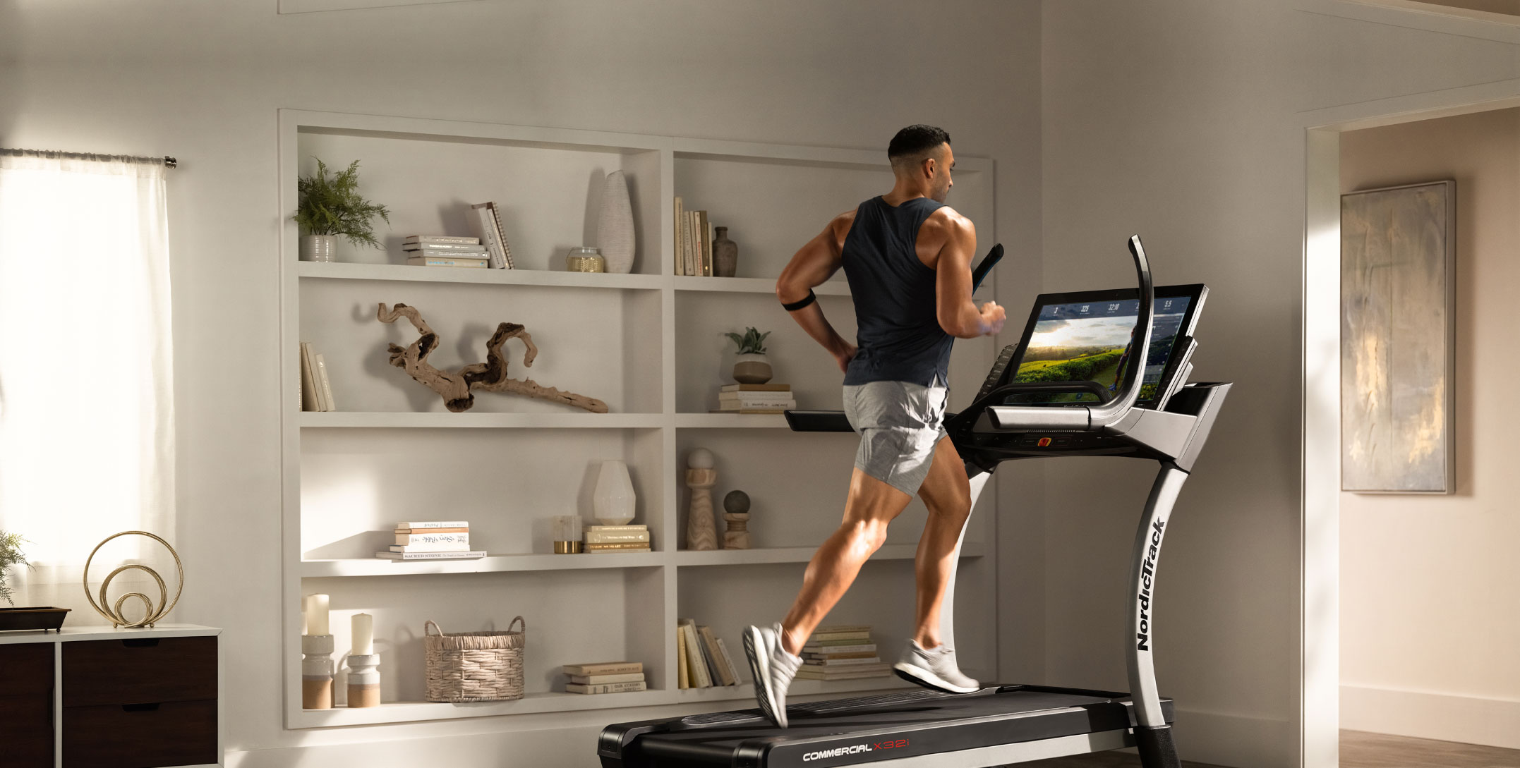 Man running on iFIT treadmill in front of bookshelf