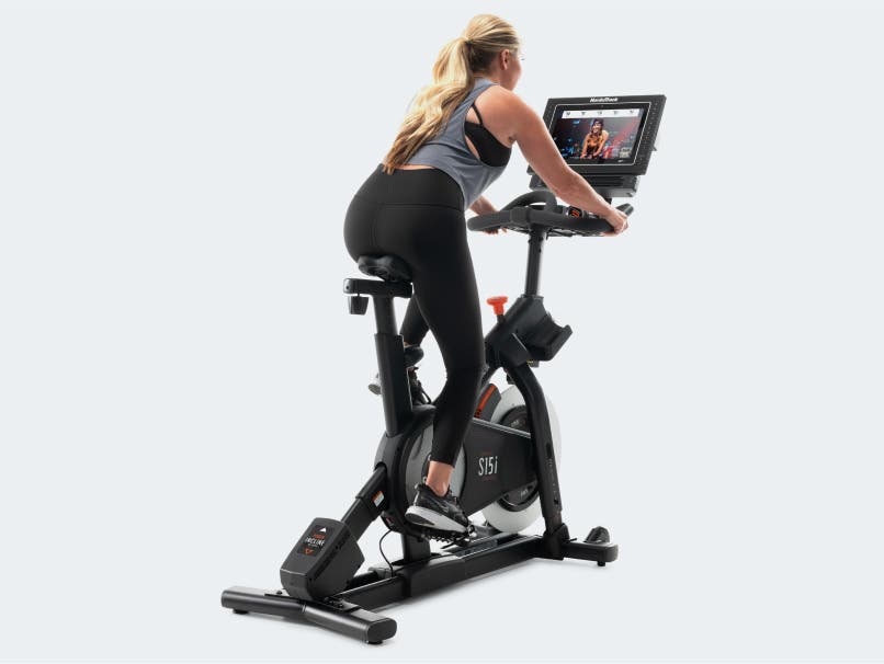 Woman rides exercise bike