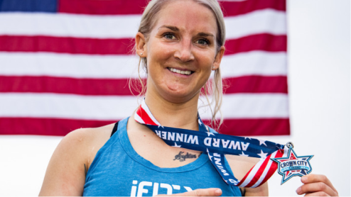 Woman in front of American flag with medal